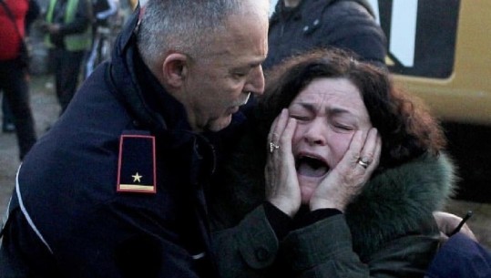 FOTO sa 1000 fjalë/ Efektivi i policisë ngushëllon një grua, të afërmit e së cilës janë bllokuar nën rrënoja