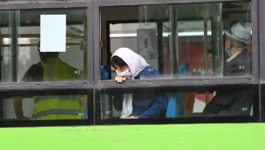 Me shaminë e bardhë në kokë dhe maskë, fotoja domethënëse e nënës në autobus