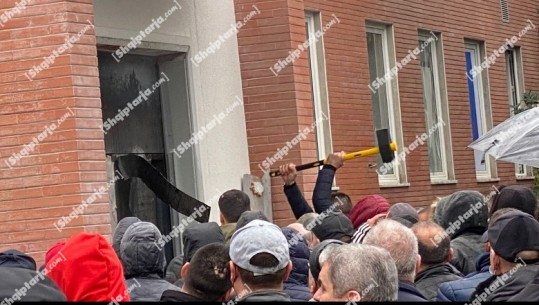 FOTO/ I dështojnë levat dhe shkopinjtë, militantët e PD marrin varenë për të shpartalluar derën e blinduar në selinë e PD