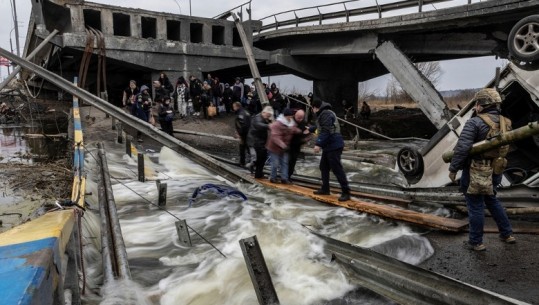 Pamje prekëse, qytetarët kalojnë mbi urën e shkatërruar për t’u larguar nga Irpin, qyteti i bombarduar nga rusët
