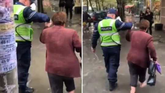 VIDEO/Pak minuta shi dhe përmbyten rrugët në Tiranë, gruaja zbathur e këpucë në dorë kalon ujin, e ndihmon polici!  