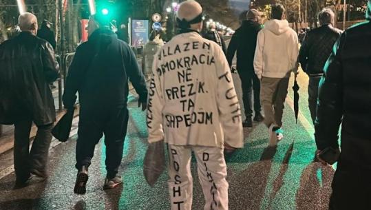 Me plis e veshje të bardhë me mbishkrime, protestuesi shpalos krijimtarinë në protestën e PD