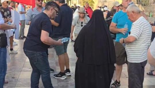 Temperaturat e larta sfidojnë protestuesit, një grua shpërndan shishe uji falas