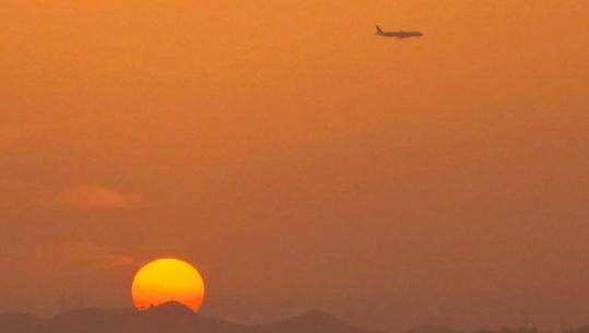 FOTOLAJM/ Perëndim spektakolar në Tiranë, avioni ‘fluturon’ mbi diellin në horizont