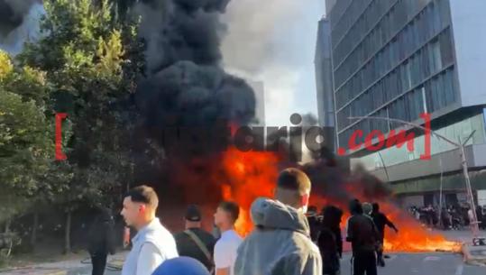 Protesta/ Zjarri djeg pemët në hyrje të sheshit ‘Skënderbej’, protestuesit 'e ushqejnë' me kosha e stola plastikë