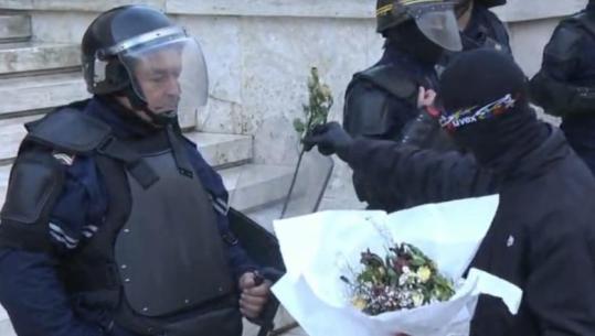Protestuesi i maskuar ‘mbulon’ policët me lule të thara, ‘u dhuron’ puthje