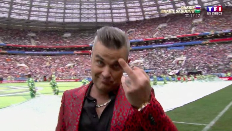 Robbie Williams tregon gishtin e mesit gjatë performancës së hapjes së Botërorit