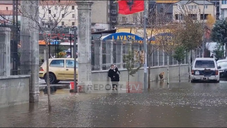 Reshjet e dendura të shiut përmbytin rrugët e qytetit në Bulqizë, qytetarët detyrohen të kalojnë përmes ujit