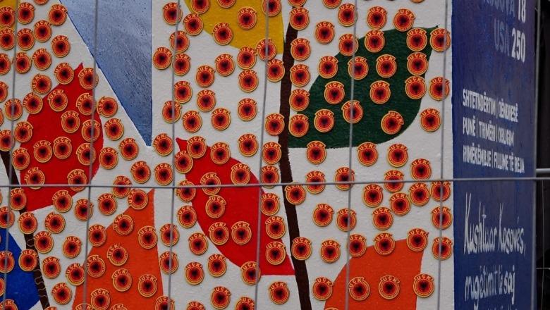 Pas grilës së hekurt, monumenti ‘Newborn’ në Prishtinë mbulohet nga 5000 emblema të UÇK-së