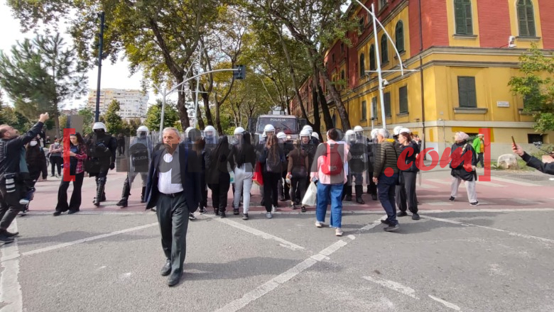Protestuesit në marshim, një grup vajzash përpiqet të pengojë policinë