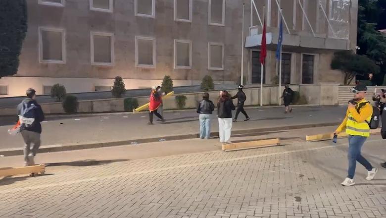 Dy protestuesit e maskuar thyejnë me hekur ndriçuesit te Kryeministria! Gjuajnë edhe dritaret (VIDEO)